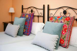 un grupo de almohadas sentado encima de una cama en Chalet con magníficas vistas al mar en Perlora