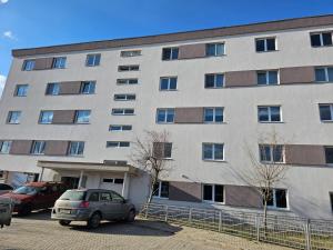 un gran edificio con coches estacionados frente a él en Zack Apartments, en Murfatlar