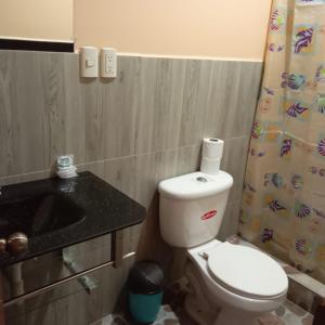 a small bathroom with a toilet and a sink at Centro Vacacional RECREASANA in Puerto López