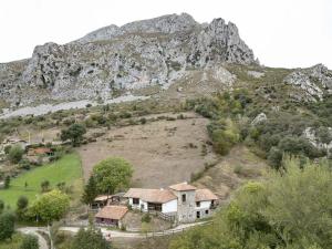una casa en una colina frente a una montaña en Albergue de Cabañes, en Cabañes
