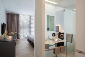Habitación de hotel con cama y lavabo en INNSiDE by Meliá München Parkstadt Schwabing en Múnich