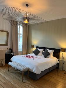 Un dormitorio con una cama grande con flores rojas. en La Demeure des Sacres - Cathédrale en Reims