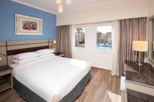 Habitación de hotel con cama grande y ventana en Swiss Inn Resort Hurghada, en Hurghada