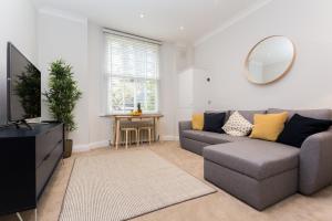 a living room with a couch and a mirror at Vibrant 1BR Apt wPrivate Decked Garden, Fast WIFI in London