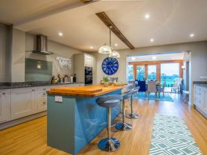 a kitchen with a blue island with bar stools at 5 bed in Llangollen 77696 in Whitchurch