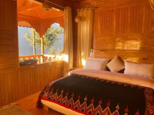 a bedroom with a bed and a window at narayanatreecottage in Kasol