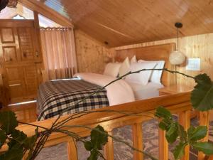 a bedroom with a bed in a wooden cabin at narayanatreecottage in Kasol