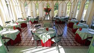 uma sala de jantar com mesas e cadeiras num quarto com janelas em Château de Courcelles em Courcelles-sur-Vesle