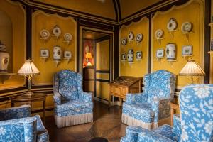 ein Zimmer mit 2 Stühlen und einem Tisch und Platten an der Wand in der Unterkunft Château de Courcelles in Courcelles-sur-Vesle