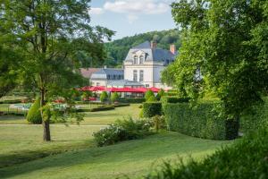 une grande maison blanche avec une clôture dans un parc dans l'établissement Château de Courcelles - Relais & Châteaux, à Courcelles-sur-Vesle
