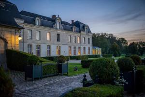 une grande maison avec un jardin devant dans l'établissement Château de Courcelles - Relais & Châteaux, à Courcelles-sur-Vesle