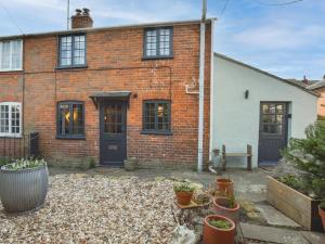 a brick house with a courtyard with potted plants at 1 Bed in Bridport 89687 in Bridport