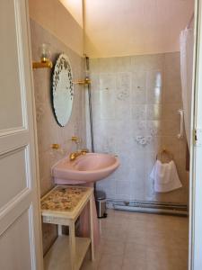 baño con lavabo rosa y espejo en Chateau Le Plessis, en Sémelay