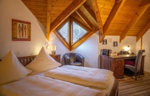 a bedroom with two beds and a desk and a window at Hotel-Restaurant Eifeler Seehütte in Rieden