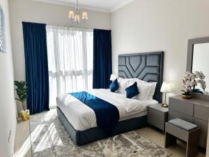 ドバイにあるDunya Tower Luxury and 2 min walk to Dubai Mall and Burj Khalifaのベッドルーム1室(青いカーテン付きの大型ベッド1台付)