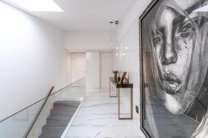a large painting of a woman on a wall in a hallway at Golfe Villa ' Paraíso de Luxo ' Piscina Aquecida in Ponte de Lima