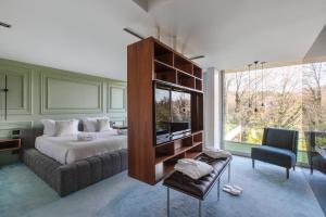 a bedroom with a bed and a couch and a window at Golfe Villa ' Paraíso de Luxo ' Piscina Aquecida in Ponte de Lima