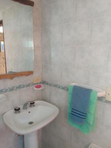 a white bathroom with a sink and a mirror at CABAÑAS EL PALENQUE in Esquel