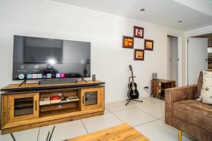 sala de estar con TV y sofá en The Escalante, en Johannesburgo