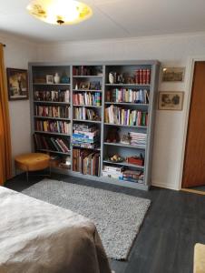 ein Schlafzimmer mit einem Bücherregal voller Bücher in der Unterkunft Som hemma in Grästorp