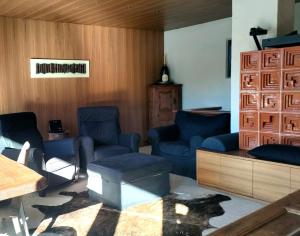 une salle d'attente avec des chaises bleues et un mur en bois dans l'établissement "Lo Chalet 450" vicino Cortina d'Ampezzo, à Borca di Cadore