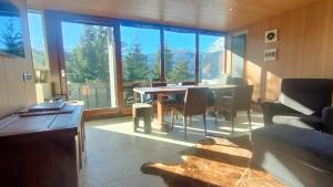 a living room with a table and chairs and a large window at "Lo Chalet 450" vicino Cortina d'Ampezzo in Borca di Cadore