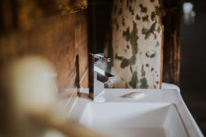 a bathroom with a faucet on top of a sink at Hotel-Restaurant Eifeler Seehütte in Rieden