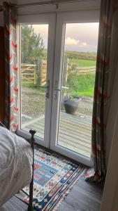 um quarto com uma porta de correr e vista para um quintal em Lovely 1-Bed Lodge in Haverfordwest with views em Haverfordwest