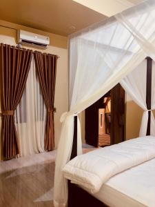 um quarto com uma cama de dossel e cortinas em R5 Keramba Inn em Bukit Lawang