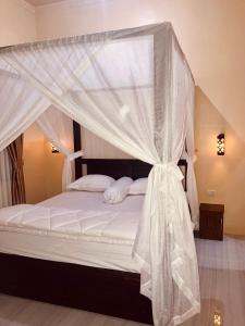 um quarto com uma cama de dossel com cortinas brancas em R5 Keramba Inn em Bukit Lawang