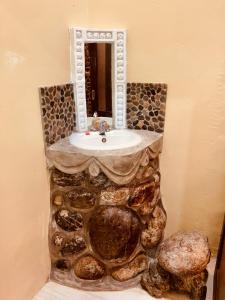 uma casa de banho com um lavatório de pedra e um espelho. em R5 Keramba Inn em Bukit Lawang