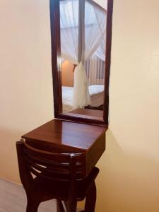 a wooden dresser with a mirror on top of it at R5 Keramba Inn in Bukit Lawang