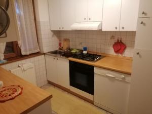 a kitchen with white cabinets and a stove top oven at Belle Maison in Folgaria