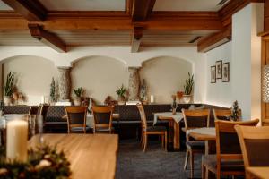 ein Restaurant mit Holzdecken, Tischen und Stühlen in der Unterkunft Hotel Lerch in St. Johann im Pongau