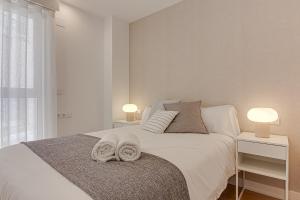 a bedroom with a white bed with towels on it at Santa Lucía in A Coruña