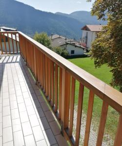 a wooden balcony with a view of a field at Belle Maison in Folgaria