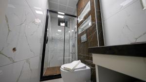 y baño con ducha y aseo con lavamanos. en Mitra otel en Diyarbakır