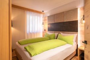 a bedroom with a bed with green pillows at B&B al Borgo in San Lorenzo in Banale