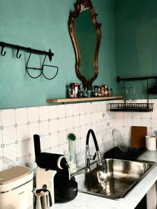 a kitchen with a sink and a mirror on the wall at Casa di Luca in Viareggio