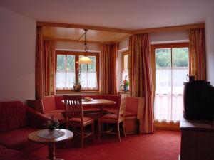 a living room with a table and chairs and a couch at Landhaus Marten in Saalbach-Hinterglemm