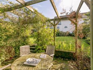 a table and chairs in a garden with a pergola at 2 Bed in Goudhurst 51229 in Goudhurst