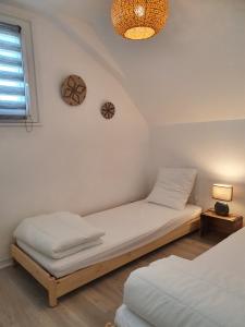 a bedroom with two beds and a chandelier at Voile et Plage, Villa 3 étoiles à La Trinité sur Mer in La Trinité-sur-Mer