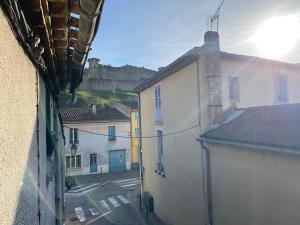 een raam met uitzicht op een straat met gebouwen bij La Maison du Roi Arthur in Carcassonne