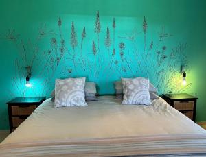 a bedroom with a bed with a blue wall at Dragon & Eagle in Lydenburg