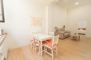 ein Wohnzimmer mit einem Tisch, Stühlen und einem Sofa in der Unterkunft Apartamento a estrenar en San Bernardo in Sevilla