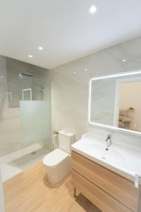 a bathroom with a toilet and a sink and a mirror at Apartamento a estrenar en San Bernardo in Seville