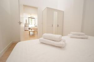 two stacks of white towels sitting on top of a bed at Apartamento a estrenar en San Bernardo in Seville