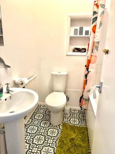 een badkamer met een wit toilet en een wastafel bij The Captains Lookout-Sleeps 6! in St. Leonards