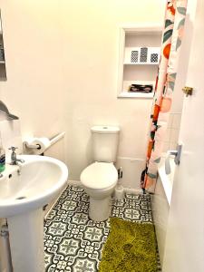 a bathroom with a white toilet and a sink at The Captains Lookout-Sleeps 6! in St. Leonards