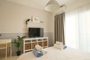 ein weißes Schlafzimmer mit Fernseher und Bett in der Unterkunft MyGuest Cornelius 29, Luxury Studio Apartment in Iskele